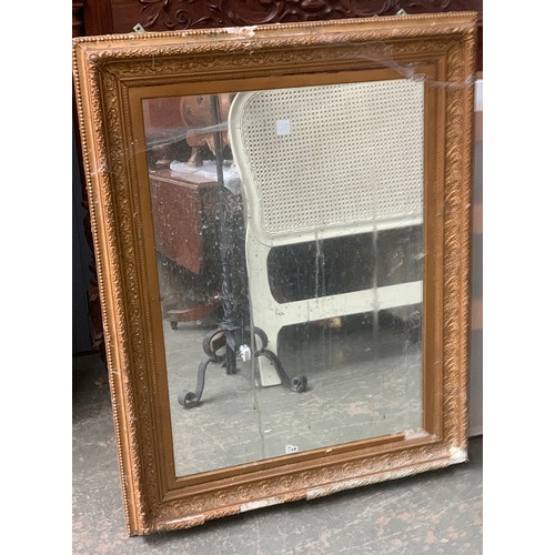 984 - A large gilt gesso picture frame, as found, with mirrored plate