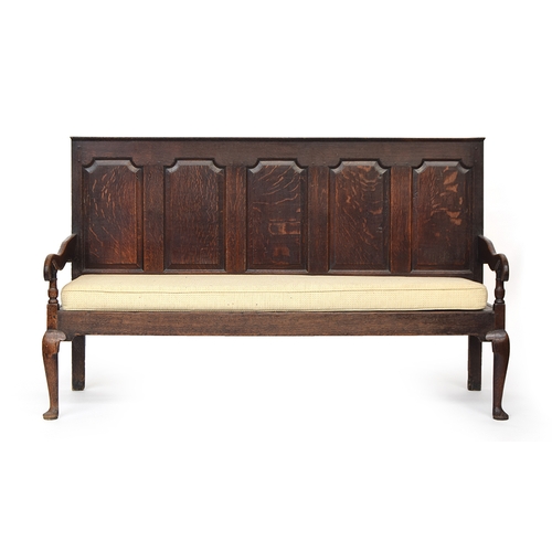 565 - A George III oak five panel settle, circa 1770, the panel back above a pair of open ends and solid 
... 