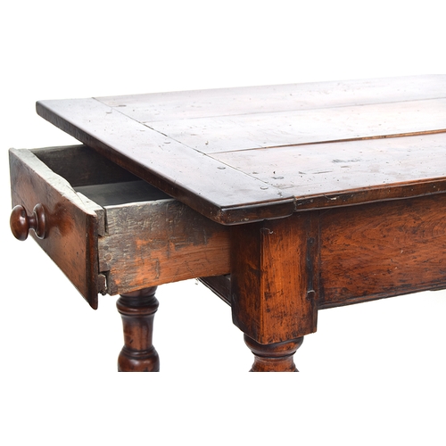 563 - A fruitwood and oak refectory style table, three plank top with cleated ends, single end drawer, on ... 