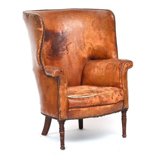 697 - A 19th century leather wingback armchair, curved back, with close-nail leather upholstery on turned ... 