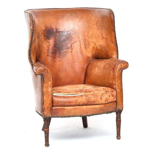 697 - A 19th century leather wingback armchair, curved back, with close-nail leather upholstery on turned ... 