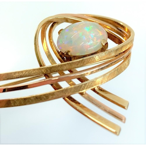 13 - A 14ct gold modernist brooch set with a large opal cabochon, approx. 7.4g, 5cm wide