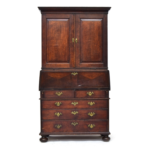 569 - A George II oak bureau bookcase estate cupboard, moulded pediment over two fielded panel doors, open... 