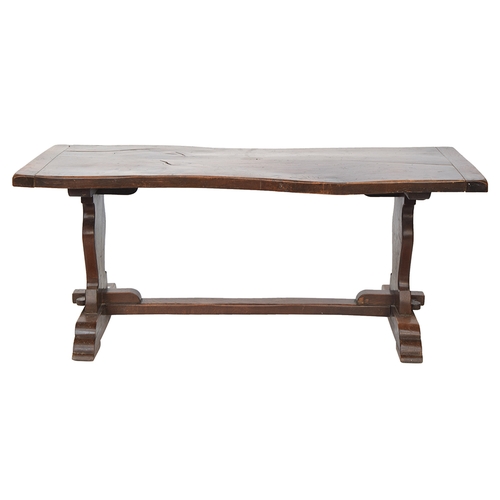 564 - An oak refectory table, two plank cleated top, each support with carved shield motif, 181cm wide, 83... 