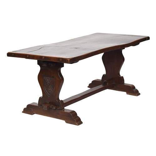 564 - An oak refectory table, two plank cleated top, each support with carved shield motif, 181cm wide, 83... 