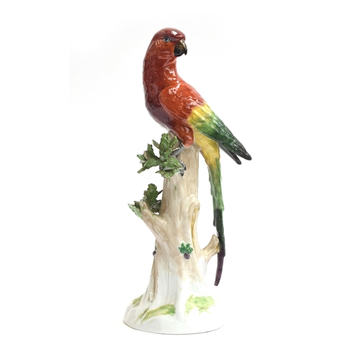 216 - A 20th century Dresden porcelain model of a parrot perched upon a tree stump, marked to base with un... 