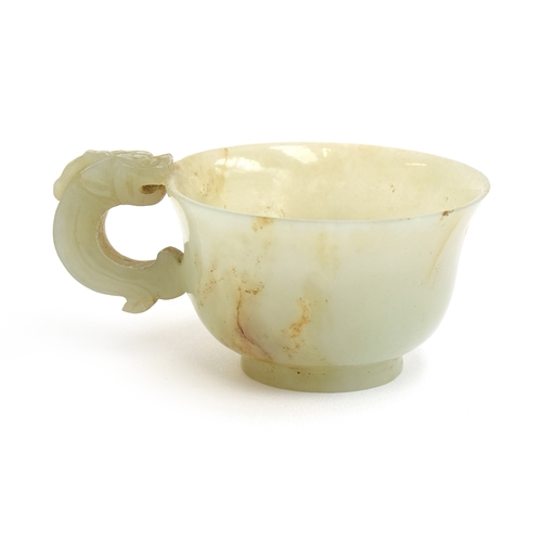 178 - A Chinese celadon and russet jade libation cup, the handle in the form of a dragon, 4cm high