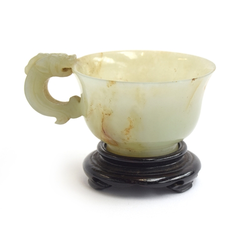 178 - A Chinese celadon and russet jade libation cup, the handle in the form of a dragon, 4cm high