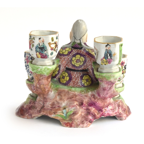 186 - A 19th century porcelain chinoiserie figural inkwell in the form of a seated sage surrounded by six ... 