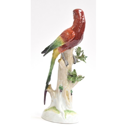 216 - A 20th century Dresden porcelain model of a parrot perched upon a tree stump, marked to base with un... 