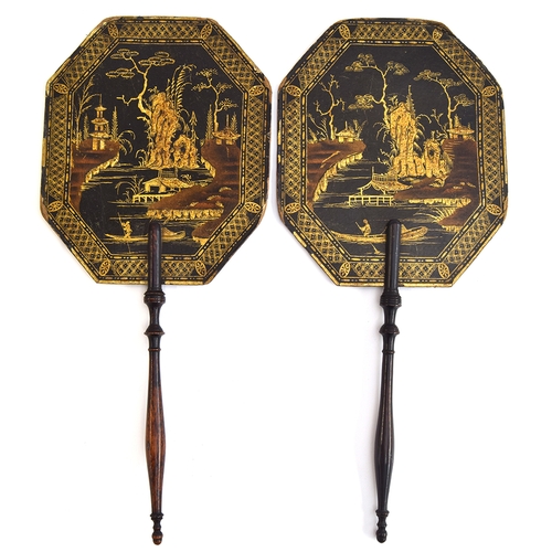 152 - A pair of 19th century lacquered papier mache fans with ebonised turned wood handles, gilt painted w... 