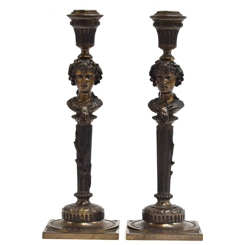 145 - A pair of French bronze candlesticks cast as Bacchante maidens, on tapering fluted columns, and squa... 