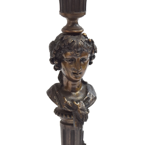 145 - A pair of French bronze candlesticks cast as Bacchante maidens, on tapering fluted columns, and squa... 