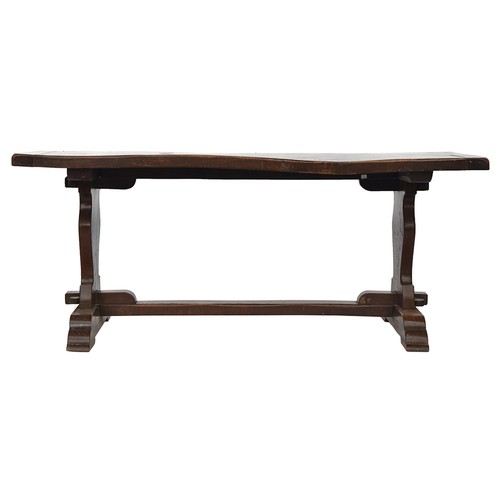 564 - An oak refectory table, two plank cleated top, each support with carved shield motif, 181cm wide, 83... 