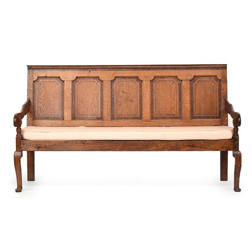 566 - A George III oak and mahogany crossbanded settle, the moulded back rail above five invert moulded pa... 