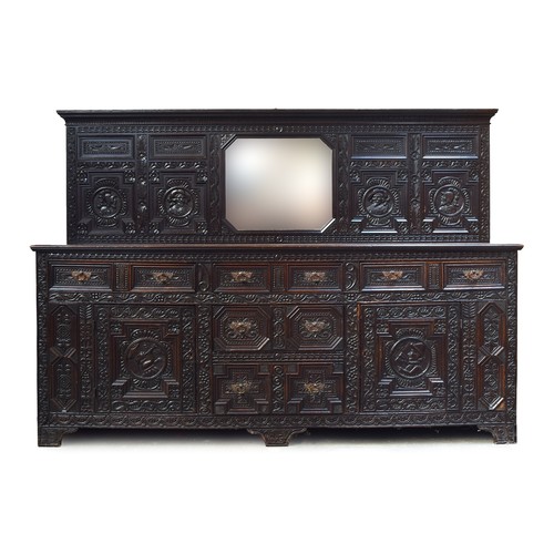 587 - A very substantial late Victorian oak sideboard, the upstand with central mirror, the whole carved p... 