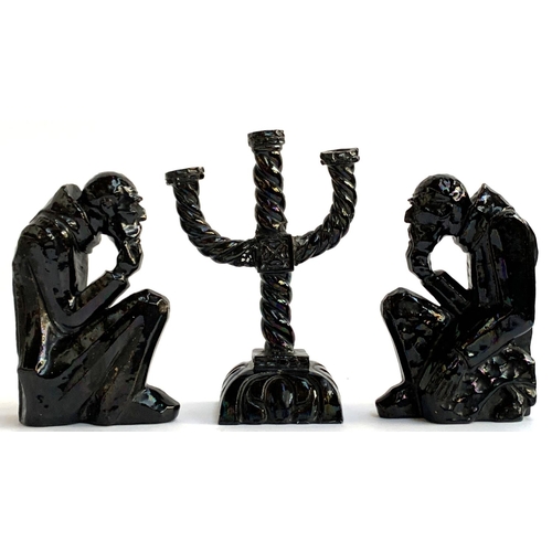 77 - A black lustre glazed three arm candlestick holder, 29cmH, together with 2 matching figures in the f... 