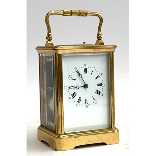 67 - A heavy gilt metal carriage clock, bevelled glass panels, enamel dial with Roman numerals, striking ... 