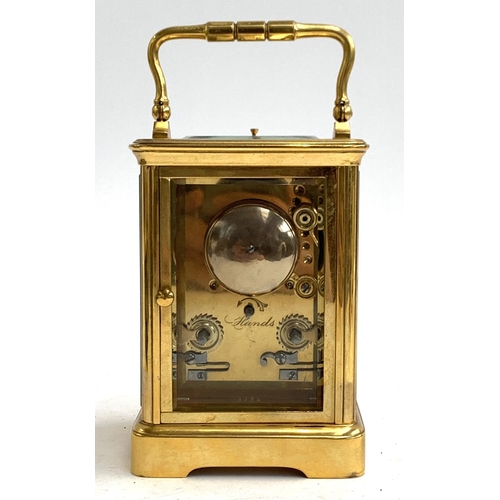 67 - A heavy gilt metal carriage clock, bevelled glass panels, enamel dial with Roman numerals, striking ... 