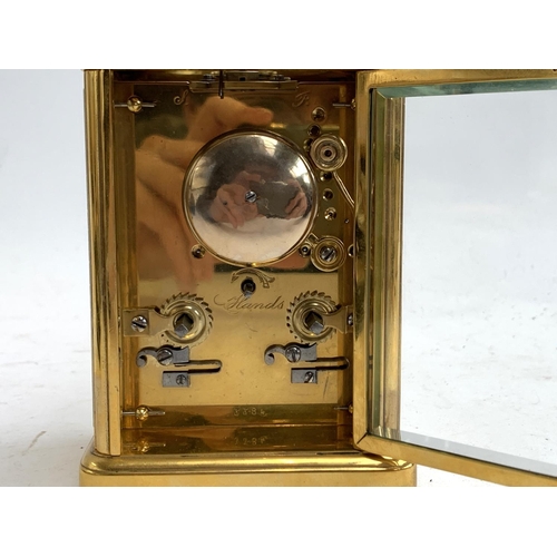 67 - A heavy gilt metal carriage clock, bevelled glass panels, enamel dial with Roman numerals, striking ... 