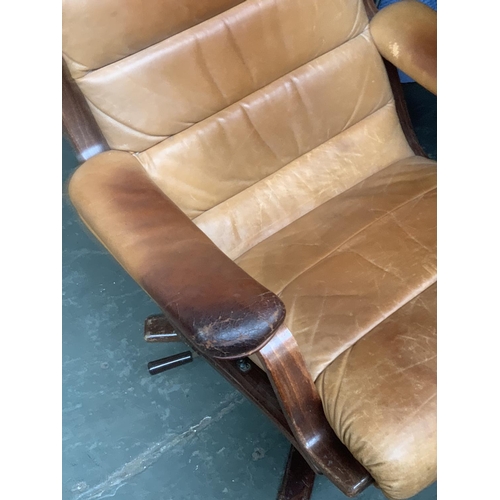 640 - A Danish leather reclining swivel chair, in need of restoration