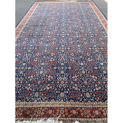 745 - A very large Turkish rug, marked 'J. 1987. G = HEREKE', blue ground with floral design, 620x343