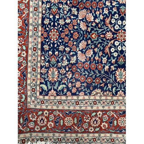 745 - A very large Turkish rug, marked 'J. 1987. G = HEREKE', blue ground with floral design, 620x343