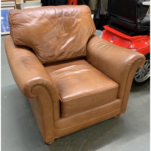 845 - A brown leather armchair with outward scrolling arms, on turned wooden feet, 92cmW