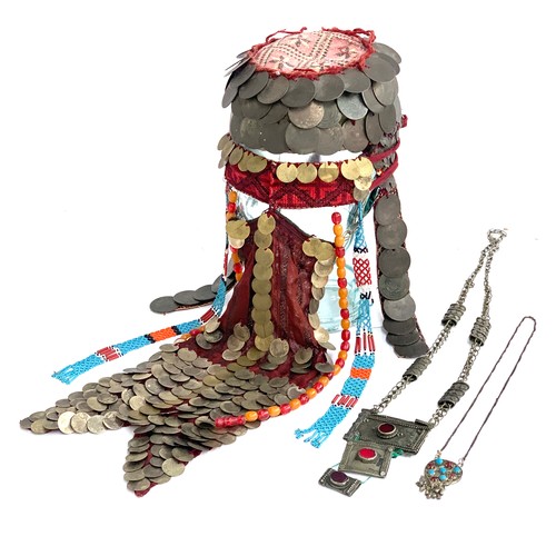 169A - A Palestinian bridal wedding headdress and burqa veil, the woven cap mounted with coins from the Ott... 