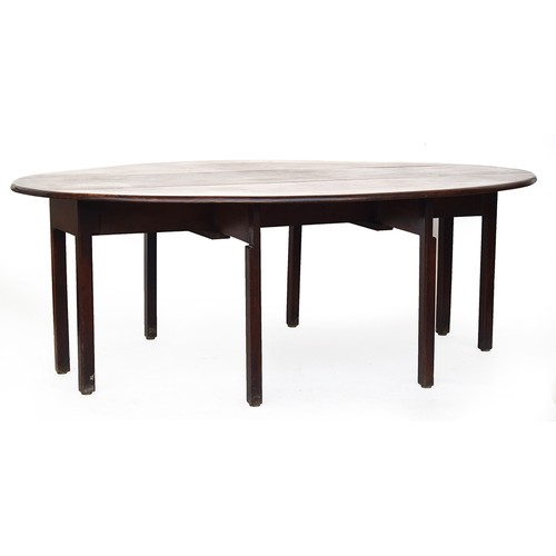 636 - A George III mahogany wake table, the top with hinged drop leaves, on eight moulded square section l... 