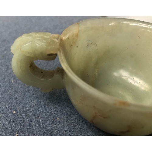 178 - A Chinese celadon and russet jade libation cup, the handle in the form of a dragon, 4cm high