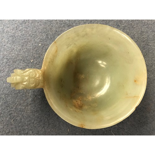 178 - A Chinese celadon and russet jade libation cup, the handle in the form of a dragon, 4cm high