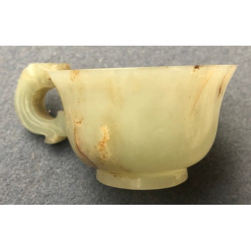 178 - A Chinese celadon and russet jade libation cup, the handle in the form of a dragon, 4cm high