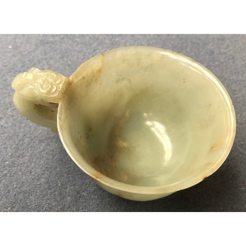 178 - A Chinese celadon and russet jade libation cup, the handle in the form of a dragon, 4cm high