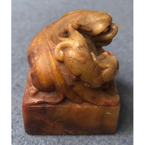 182 - A Chinese carved shoushan stone seal surmounted by a Qilin,  6.2cm high, with label to reverse; toge... 