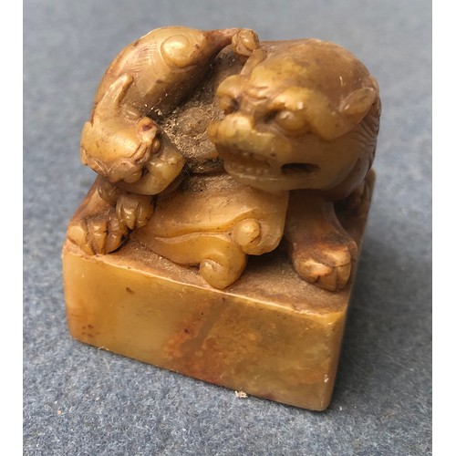 182 - A Chinese carved shoushan stone seal surmounted by a Qilin,  6.2cm high, with label to reverse; toge... 