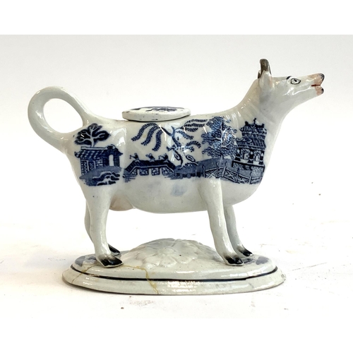 119 - A 19th century Staffordshire Willow pattern cow creamer (repairs to base)