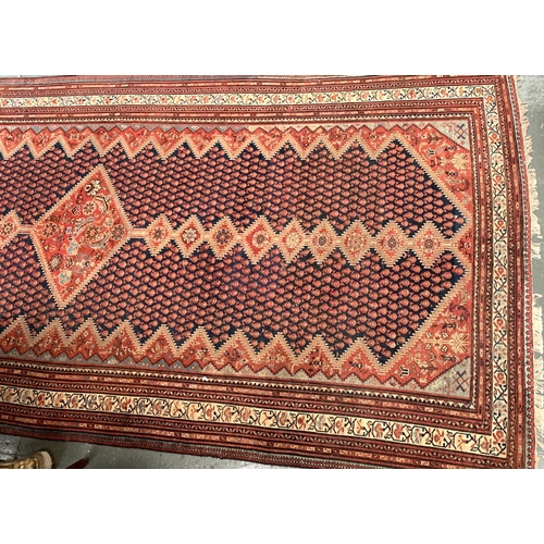 656 - A large Persian Khamseh rug, large central diamond medallion between nine smaller medallions on eith... 