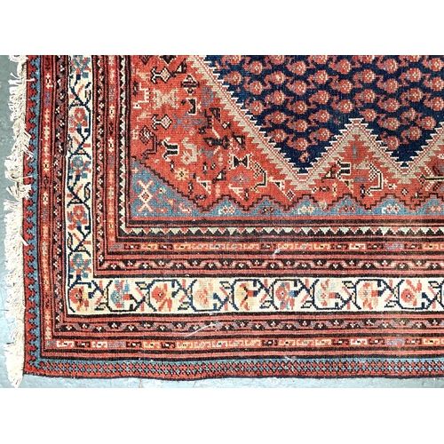 656 - A large Persian Khamseh rug, large central diamond medallion between nine smaller medallions on eith... 