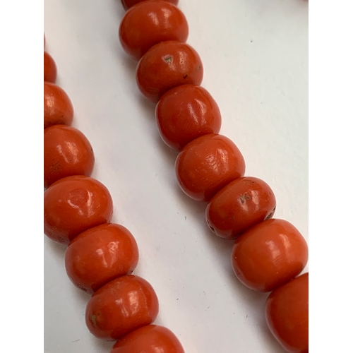 17 - A 19th century coral bead necklace (in need of restringing), each bead approx. 1cmD, with yellow met... 