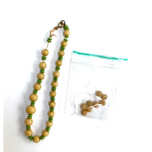 26 - A russet jade and green glass bead necklace in need of restringing