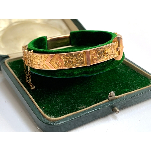 32 - An Edwardian 9ct gold bangle of buckle form, foliate engraved decoration, with safety chain, hallmar... 