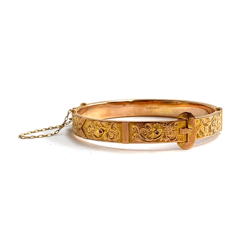 32 - An Edwardian 9ct gold bangle of buckle form, foliate engraved decoration, with safety chain, hallmar... 