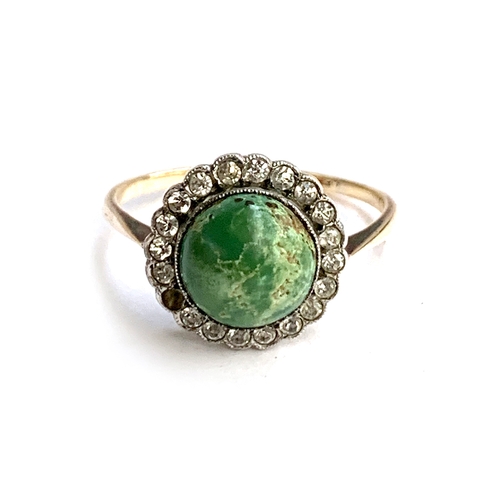 7 - An early 20th century gold ring set with a turquoise cabochon surrounded by paste (one stone missing... 