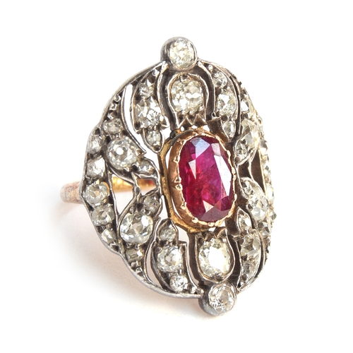 A Victorian 18ct gold and silver openwork ring, 38 old cut diamonds surrounding a central ruby, approx. 0.7ct, in a pinched collet setting, the two largest diamonds in tulip shaped settings, the head of the ring 3cm long and 2cm wide, size M 1/2, approx. 6.7g, in a maroon leather Cartier box, suede lined