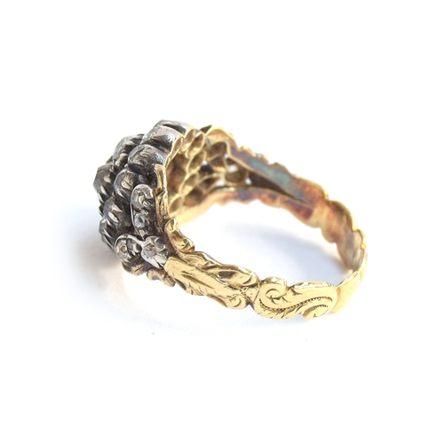 15 - A 19th century diamond cluster ring, the diamonds set in silver with a foliate engraved gold band an... 