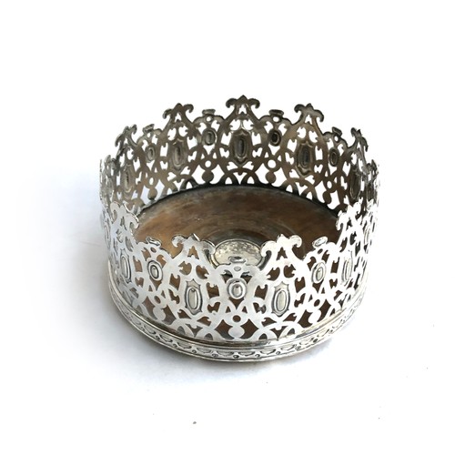 23 - A pierced white metal wine coaster, 14cm diameter, 7cm high