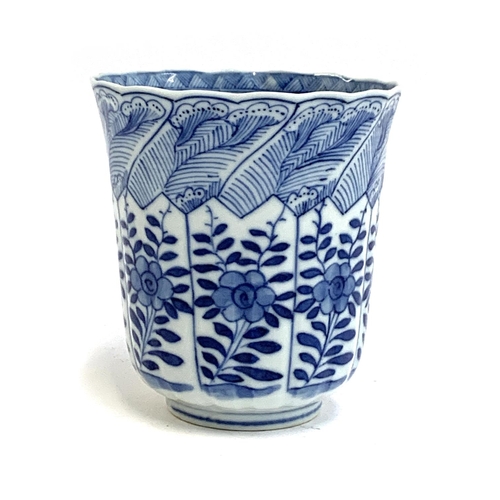 84 - A Chinese blue and white cup decorated with floral panels, marked to base with a flower in double bl... 