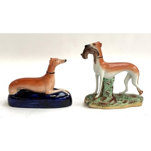 94 - A pair of Staffordshire long dog figurines, one holding quarry (af), 19cmH