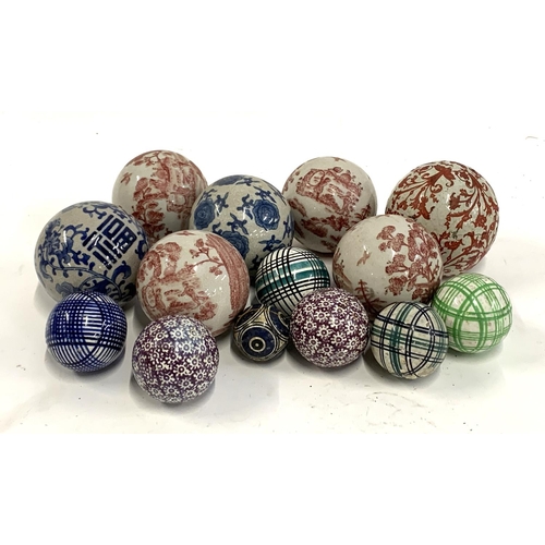 117 - A quantity of decorative ceramic balls, to include four by India Jane decorated with red pastoral sc... 